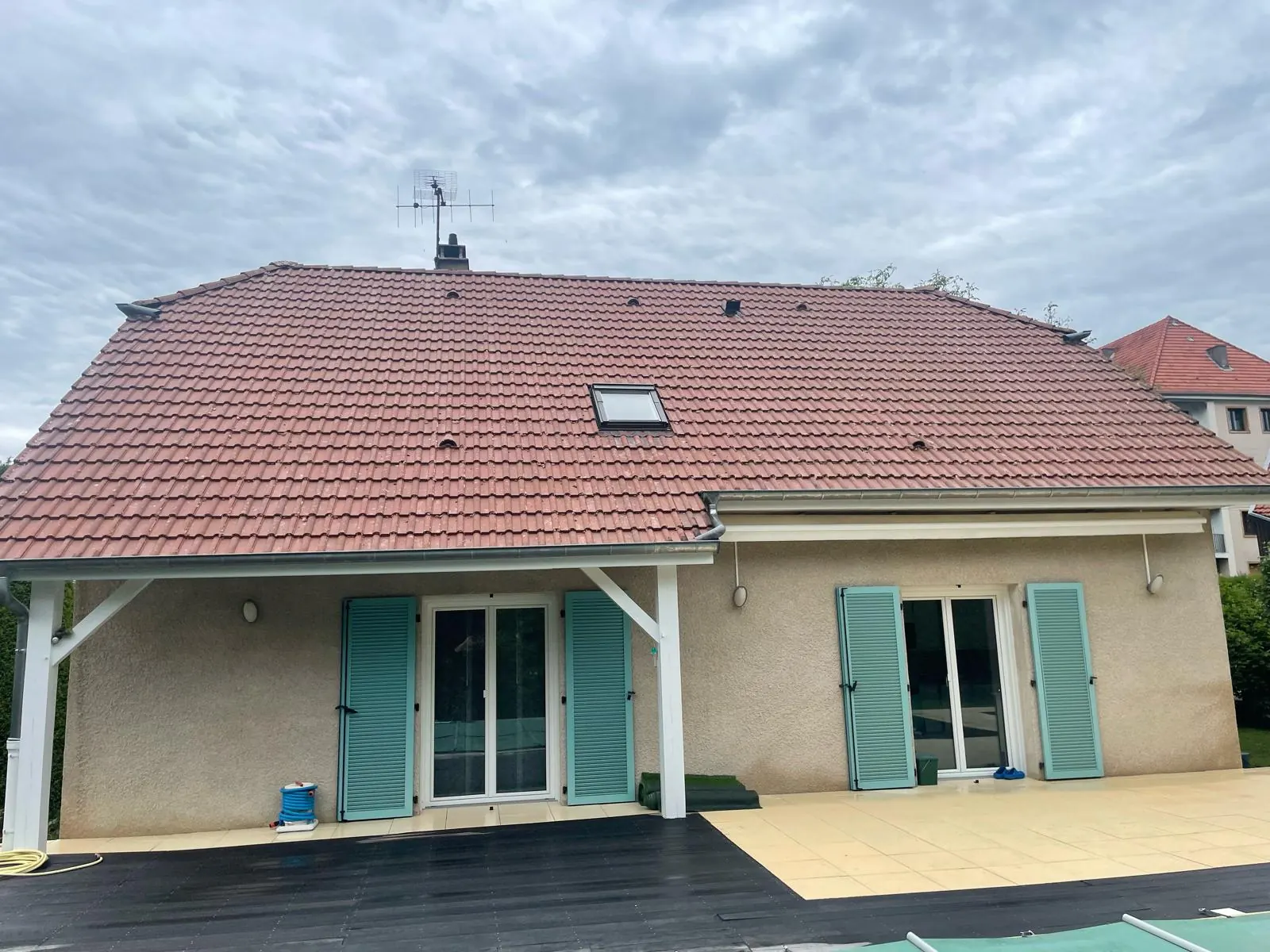 Maison à volets verts et toit en tuiles