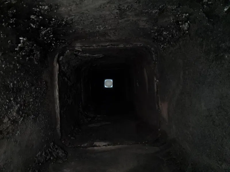 Long conduit noir avec un carré de lumière au bout